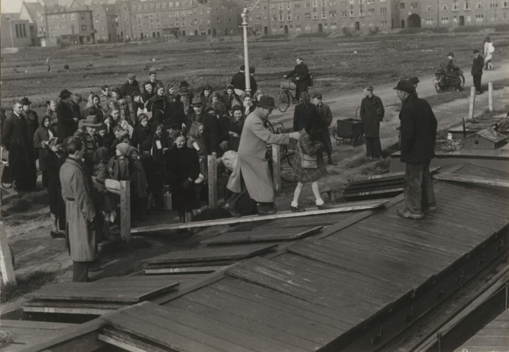 'Kinderen worden per schip naar Friesland gebracht, Den Haag (1944-1945)', credits Menno Huizinga/Nederlands Fotomuseum. Dit is de enige foto die van de kinderevacuaties tijdens de Hongerwinter is overgeleverd.