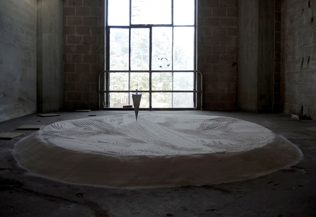 Cultivating Probability van Marjolijn Dijkman bestaat uit sculpturen, een film en geluidswerk. De objecten in de installatie zijn vrije vertalingen van rituele voorwerpen uit o.a. de collecies van Museum Volkenkunde en het Afrika Museum in Berg en Da, gemaak om de toekomst te voorspellen, of te bezweren. Deze installatie met de pendel wordt deels bewogen door de draaiing van de aarde en deels gemanipuleerd door robotica. Onderschrift en foto van de kunstenaar. Marjolijn Dijkman, 2015